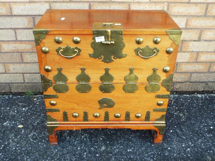 A brass mounted cabinet with fall front