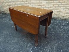 An oak drop leaf table on fluted support