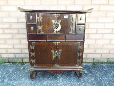 An altar style cabinet with brass mounts