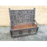 A highly carved oak box settle, carved d