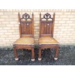 A pair of oak chairs with carved decorat