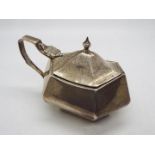 A George V silver mustard pot of hexagonal section with blue glass liner (chipped),