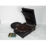 A HMV portable, table top gramophone with a small quantity of records and additional needles.