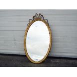 An oval framed, bevel edge wall mirror, approximately 93 cm x 51 cm.