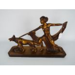 An Art Deco style plaster figural group depicting a young lady and a dog,