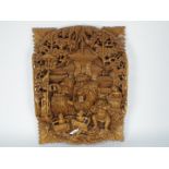 An Asian wooden wall plaque, profusely carved in high relief, approximately 52 cm x 39 cm x 4.5 cm.