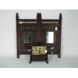 An Asian two panel folding screen, intricately carved with inset mirrors,