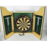 A wall mountable, twin door dartboard cabinet containing a Unicorn Maestro dartboard and darts.