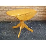 Drop leaf circular top kitchen table measuring approximately 72 cm x 93 cm.
