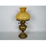 A vintage brass oil lamp with glass shade, approximately 41 cm (h).