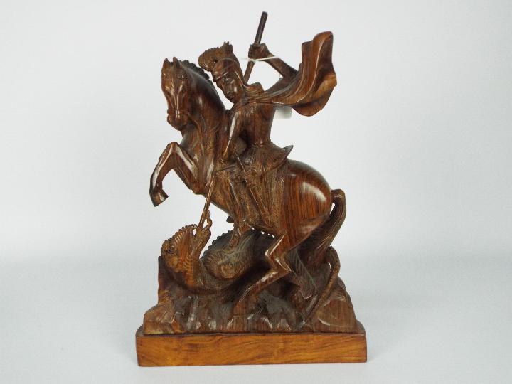 A wooden carving depicting St George and the dragon,