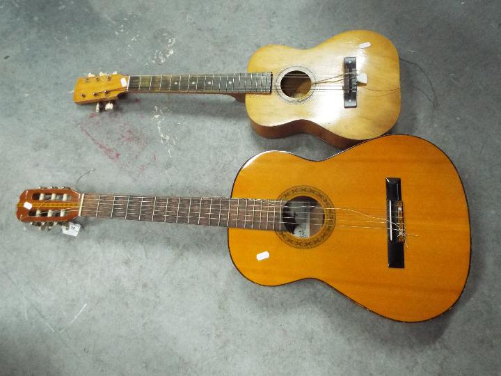 A Lorenzo acoustic guitar and a child's guitar.