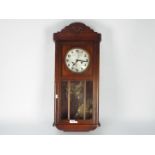 A wood cased HAC wall clock with key and pendulum.