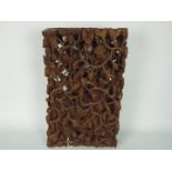 A South East Asian wooden wall plaque, profusely carved in high relief,