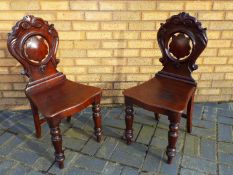 A pair of chairs with carved decoration.