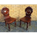 A pair of chairs with carved decoration.