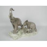 Lladro - A Lladro figural group of elephants depicting a mother elephant leading her young modelled