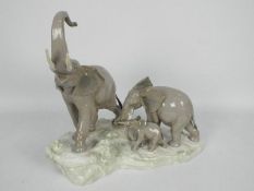 Lladro - A Lladro figural group of elephants depicting a mother elephant leading her young modelled