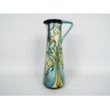 Moorcroft - A Moorcroft Pottery jug of slender form decorated in the Calla Lily pattern,