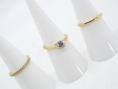 A Diamond Three Ring Set, comprising a central 18 carat gold solitaire set with a 75 point diamond,