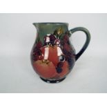 Moorcroft - A Moorcroft Pottery jug decorated in the Finches And Fruit pattern,