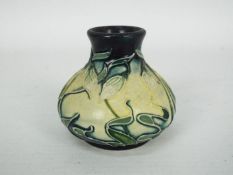 Moorcroft - A miniature Moorcroft Pottery vase decorated in the Nivalis pattern, approximately 5.