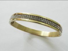Dyrberk Kern Lorbel modern bangle bracelet with a polished golden finish and clear white Swarovski