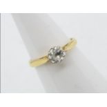 A yellow metal single stone diamond ring, approximately 0.