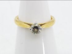 A hallmarked 18 carat yellow and white gold diamond solitaire ring, approximately .