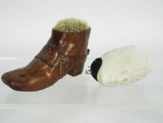Two pin cushions comprising a 19th century treen boot form example with metal studs and an unusual