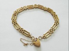 A 9 carat gold gateleg bracelet measuring approx 19 cm with detached 9 carat gold padlock clasp,
