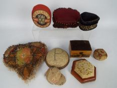A collection of early 20th century and later pin cushions to include a heart shaped material