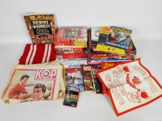 A collection of publications and videos relating to Liverpool Football Club and a scarf.