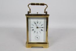 A good French brass and glass Corniche styled case striking carriage clock with alarm,