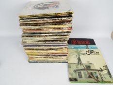 A box of 12" vinyl records to include Donovan, The Beach Boys, Elton John, Eric Clapton, Status Quo,