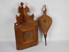 A wall mountable corner cupboard with carved foliate and floral decoration (approximately 68 cm