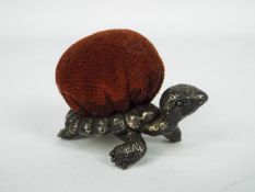 A good quality white metal pin cushion in the form of a tortoise,