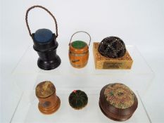 A quantity of pin cushions, predominantly treen to include ebony, Mauchline Ware,