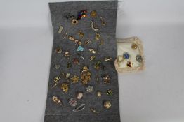 Costume Jewellery - a display containing 49 brooches with various designs
