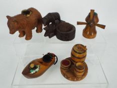 A quantity of early 20th century treen pin cushions to include a black forest carved bear on plinth,