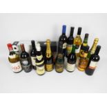 Fourteen bottles of drink, predominantly wine, including champagne, three boxed champagne flutes.