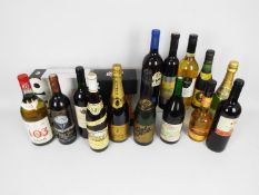 Fourteen bottles of drink, predominantly wine, including champagne, three boxed champagne flutes.