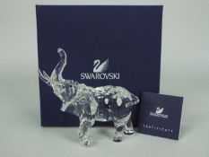 Swarovski - A boxed model of an elephant with raised trunk, with certificate.
