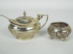 A late Victorian silver mustard pot with gadrooned decoration, hinged lid and blue glass liner,