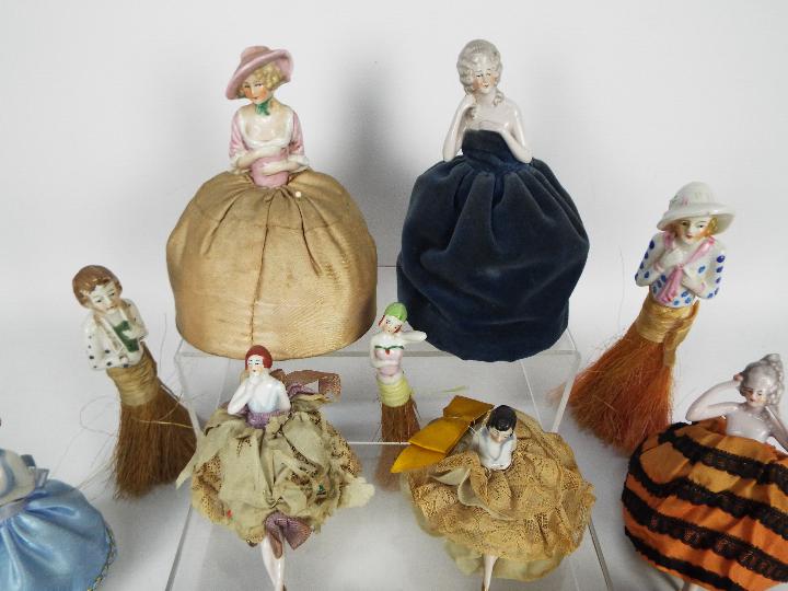A collection of early 20th century porcelain half doll pin cushions and half doll crumb brushes. - Image 2 of 5
