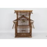 A decorative wooden bird cage containing taxidermy bird,