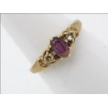 A hallmarked 9 carat yellow gold trilogy ring set with amethyst flanked by two cz stones, size M,