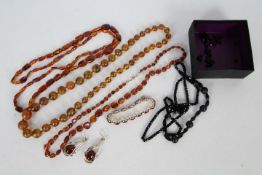 A collection of amber jewellery to include three necklaces, longest approximately 92 cm,
