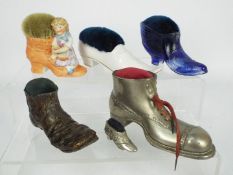 A collection of shoe / boot form pin cushions to include a blue glass example, spelter,