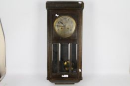 An oak cased wall clock with key and pendulum.